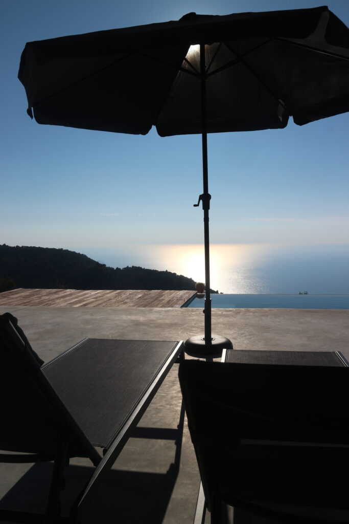 Sun beds, infinity pool, and sea view as seen from the main residence